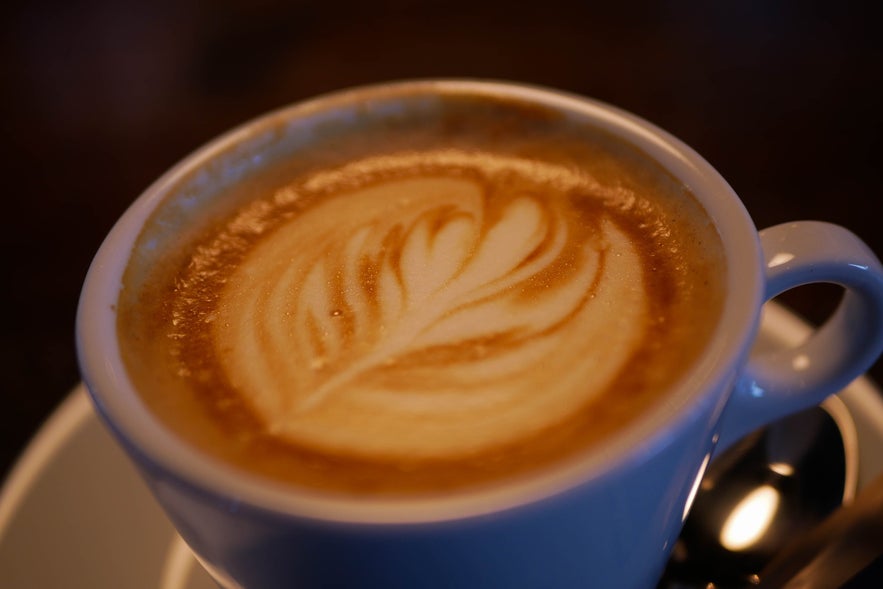 A cup of warm coffee with latte art in a cafe in Vik, Iceland.