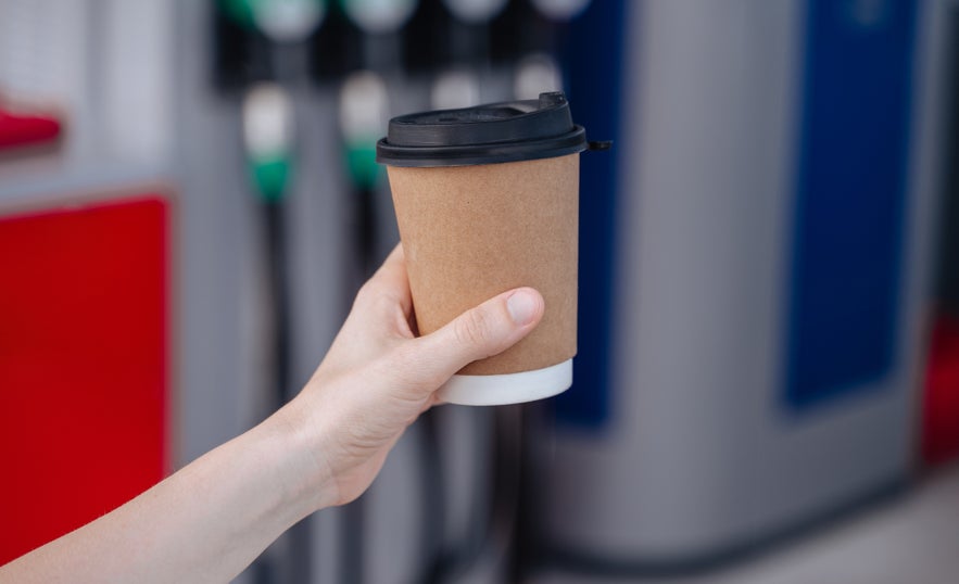 A woman holding a gas station coffee in Vik, Iceland.