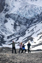 A family poses in front of snowy mountains during their tour of Thorsmork in Iceland.