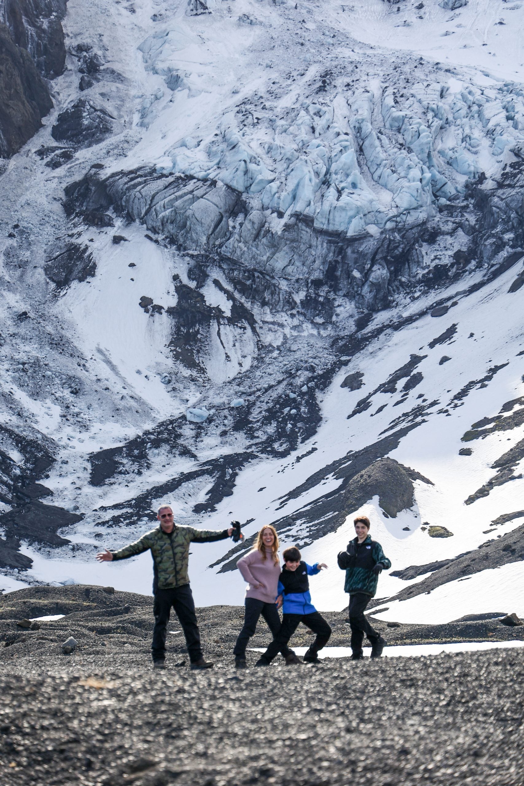 A family poses in front of snowy mountains during their tour of Thorsmork in Iceland.