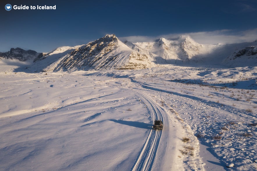 4x4 vehicle driving through snowy landscapes in South Iceland, showcasing winter road transportation in Iceland.