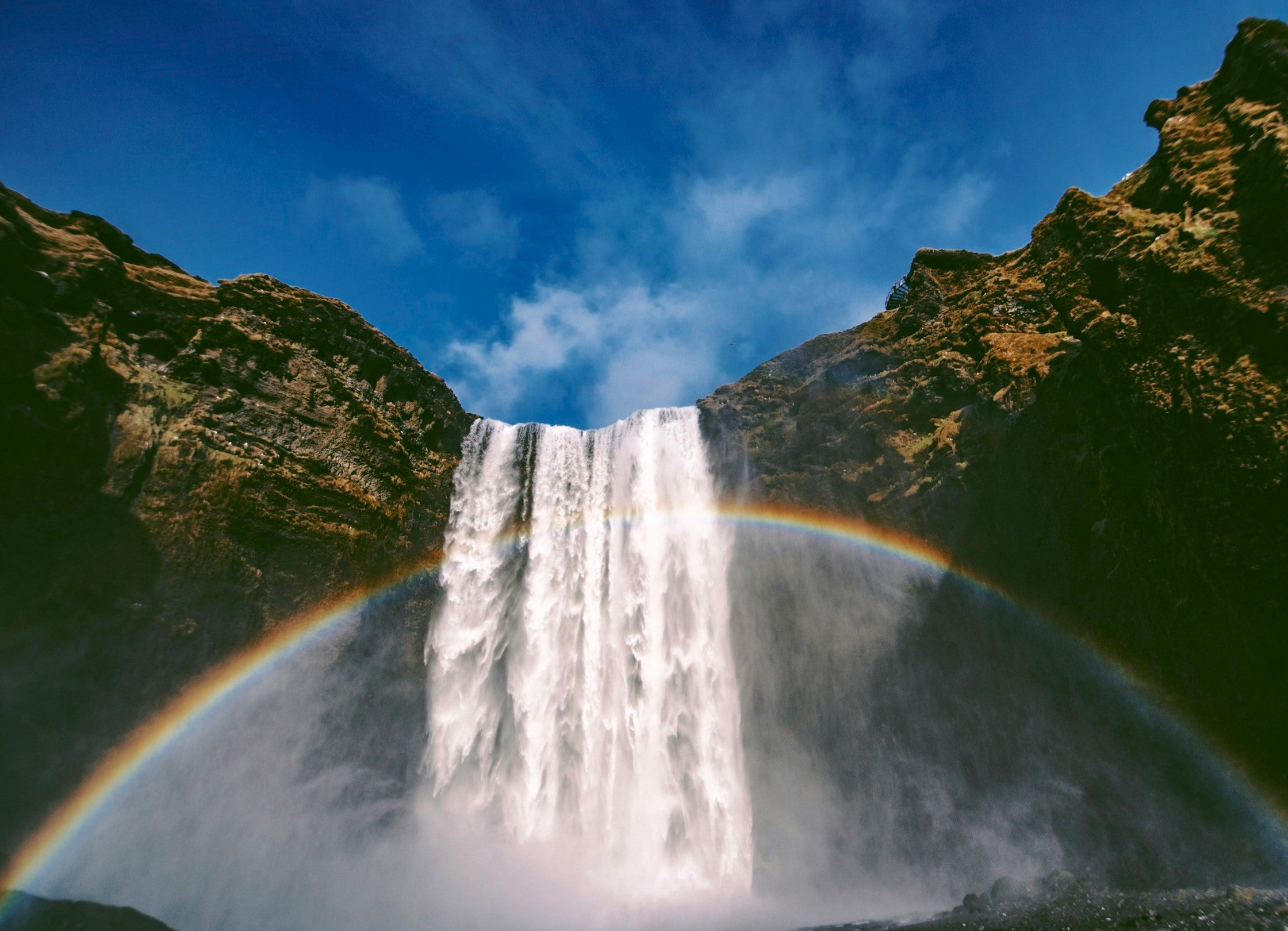 Skogafoss Waterfall in Iceland with rainbow in the mist.