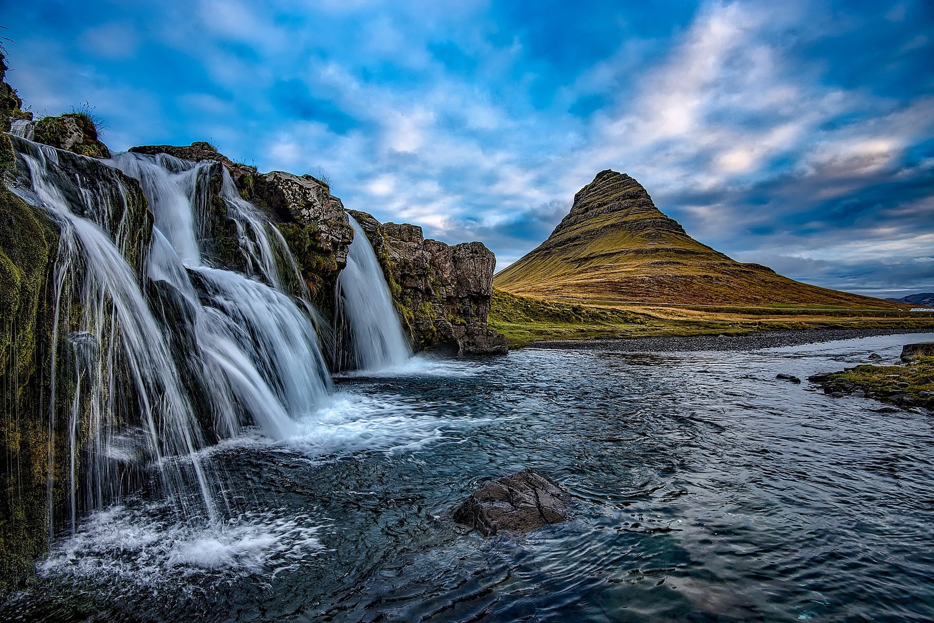 Kirkjufell Mountain in Iceland in summer, with the cascading Kirkjufellsfoss Waterfalls.