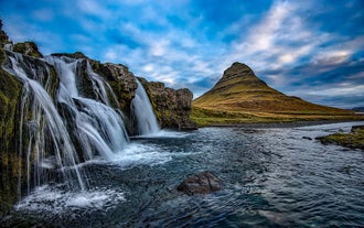 Kirkjufell Mountain in Iceland in summer, with the cascading Kirkjufellsfoss Waterfalls.