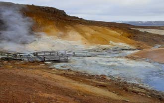 Steaming mud pots and colorful mineral hills at Krysuvik Geothermal Area in Iceland’s Reykjanes Peninsula.