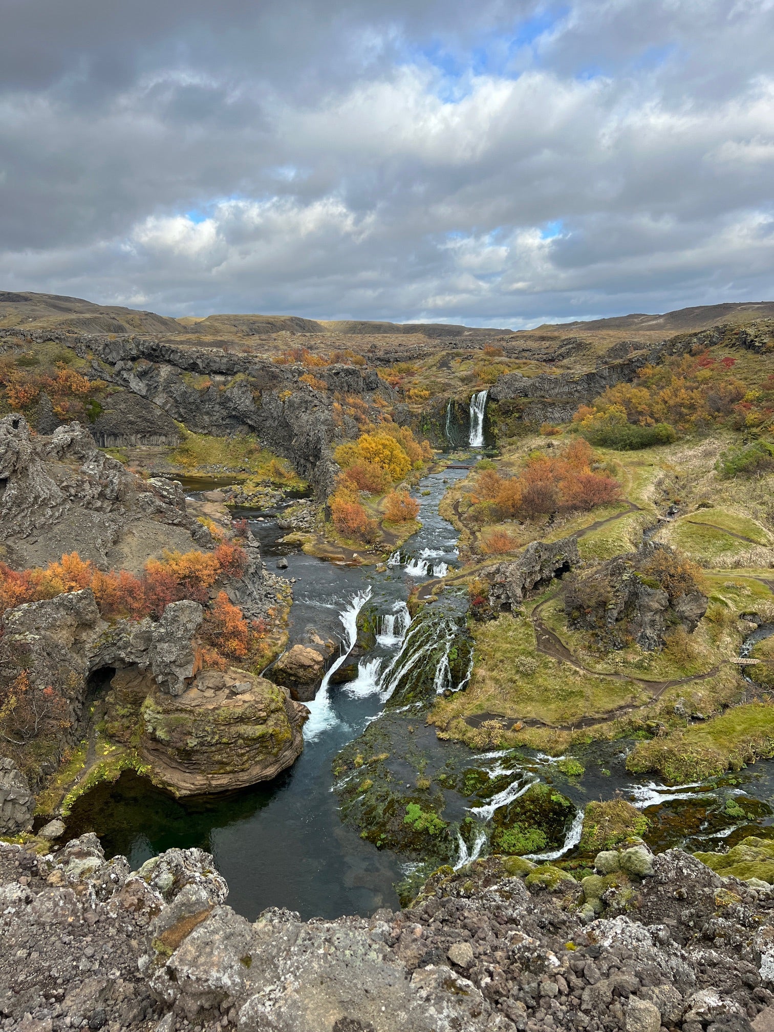 Scenic view of Gjain valley with waterfalls, lava formations, and autumn colors in the Icelandic Highlands.