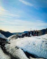 A group of friends posing after conquering the beautiful Solheimajokull glacier