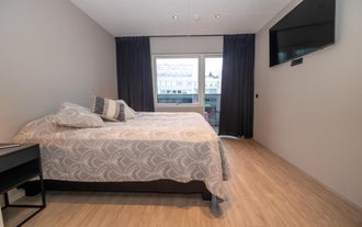 Contemporary bedroom with a double bed and a TV at S10 Stylish Apartment in Akureyri.