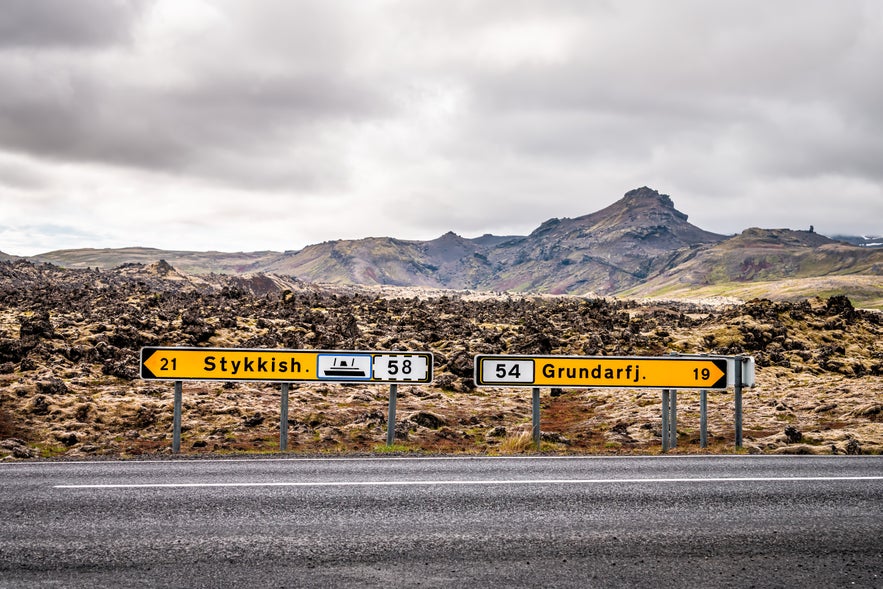A yellow Icelandic road sign pointing to Stykkish and Grundarfj in West Iceland.