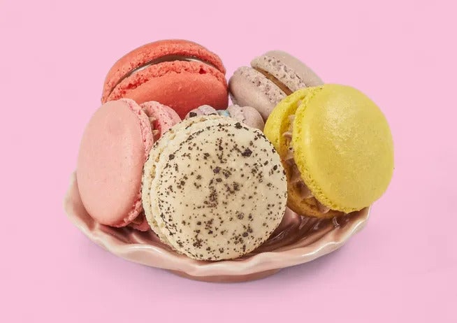 Colorful macaroons against a pink background at Sykurverk Cafe in Akureyri.