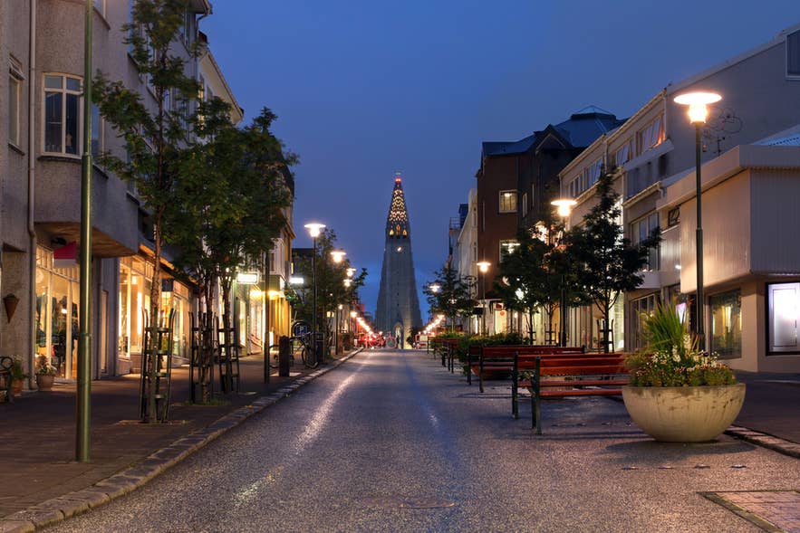 Goed verlichte, lege straat in het centrum van Reykjavik, die de veilige sfeer van de stad na zonsondergang laat zien.