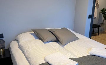 Du linge blanc et des serviettes pliées reposent sur le lit de la chambre principale du Lovely Apartment with Hot Tub Access.