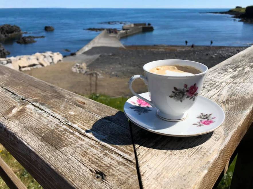 Café sur la terrasse de Fjöruhúsið avec vue sur la mer.