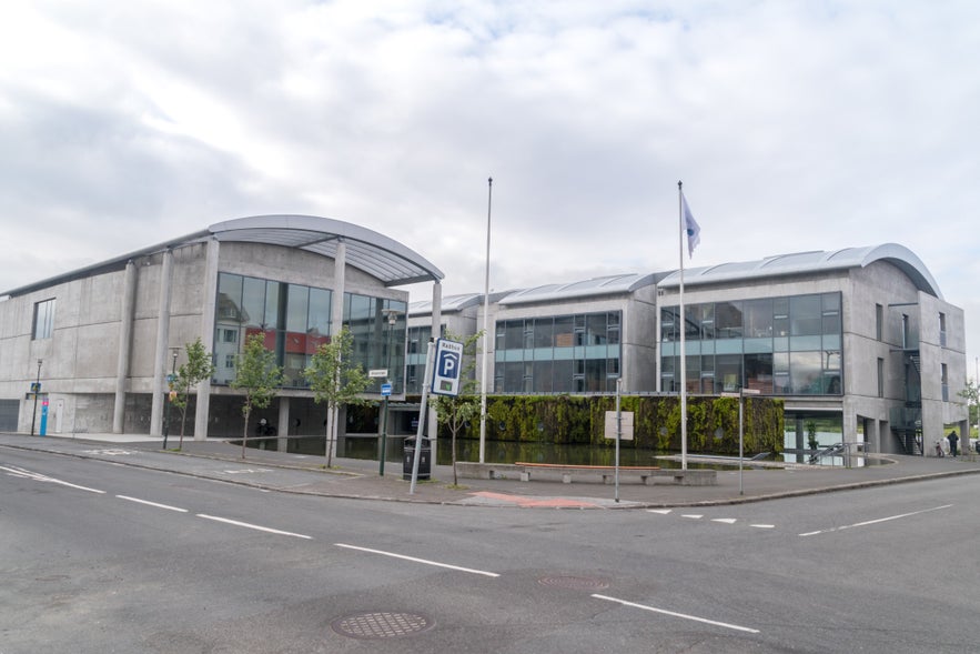 Reykjavik City Hall exterior on Tjarnargata, showing modern concrete and glass architecture beside Tjornin Pond