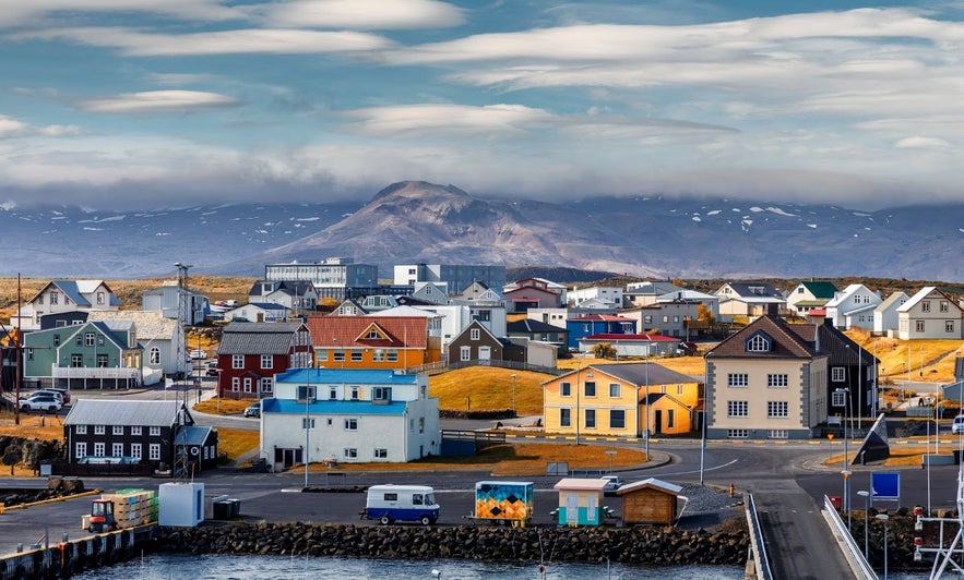 Coastal buildings in Stykkisholmur with cloudy skies and rugged terrain.