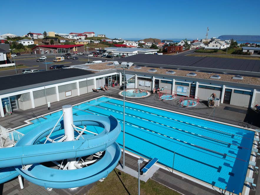 Vue aérienne de Stykkisholmur Swimming Pool avec son bassin de nage, ses bains chauds et son toboggan aquatique en spirale.