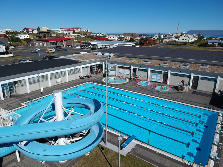 Stykkisholmur outdoor pool complex with modern facilities and town view.