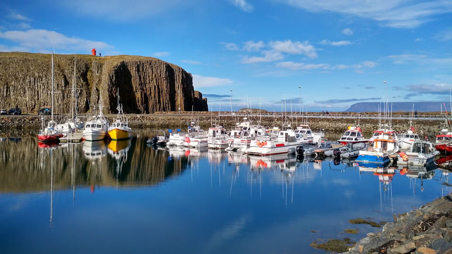 Fishing boats docked in Stykkisholmur harbor on a clear day in Iceland.