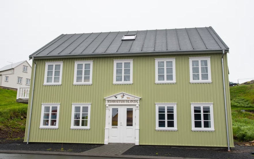 Green wooden building housing the Eider Center in Stykkisholmur, Iceland.