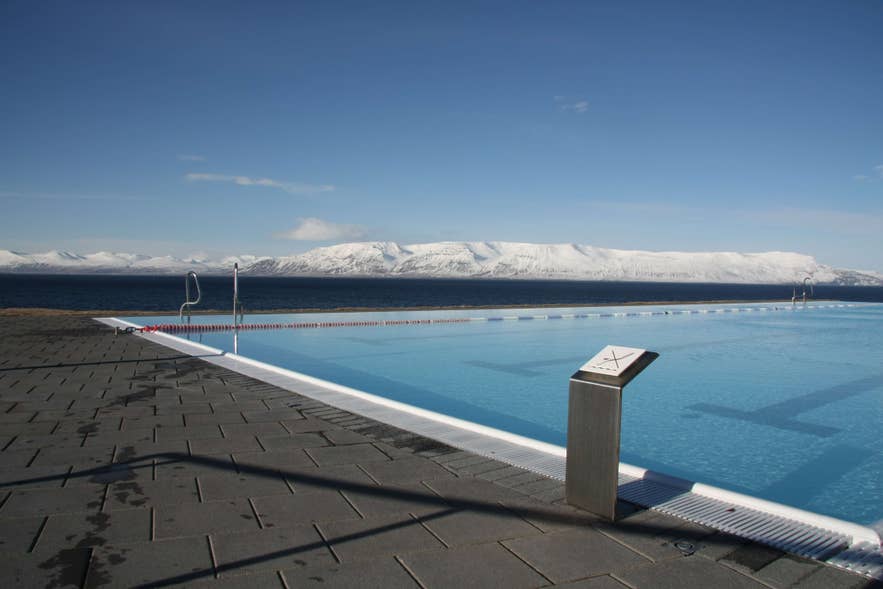 Hofsos swimming pool in North Iceland with snow covered mountains in the distance