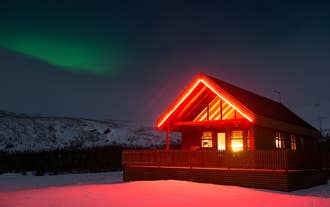 Gljufurbustadir Holiday Home illuminated at night with the northern lights in the background.