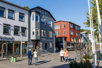 Torg Guest House sulla piazza principale di Akureyri con persone che passeggiano tra negozi ed edifici colorati.