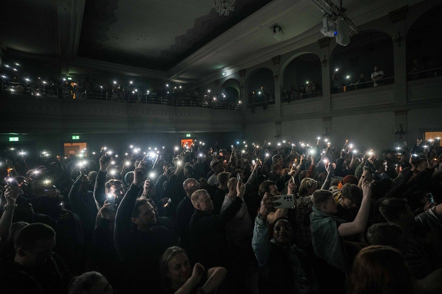 A full crowd holding their lit phones at a concert organized by Liveproject in Iceland.