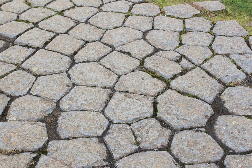 The hexagonal pattern of the basalt rock is a natural occurrence.