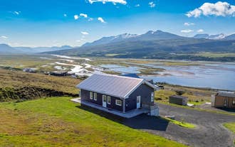 K17 Villa overlooking a wide river valley and snow-capped mountains on a sunny day.