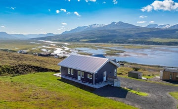 K17 Villa z widokiem na szeroką dolinę rzeki i ośnieżone góry w słoneczny dzień.