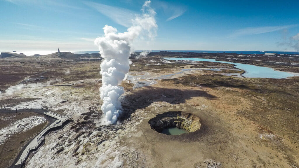 Steaming geothermal vents at Gunnuhver Hot Springs in Reykjanes Peninsula, Iceland, with bubbling mud pools and rising sulfur mist in a volcanic landscape.