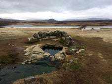 The Landbrotalaug hot spring is hidden behind a small rock wall, making it private and secluded.