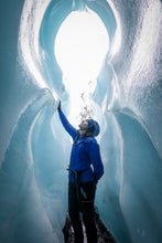 Woman admiring glacial ice during an ice climbing tour on Solheimajokull Glacier in Iceland.