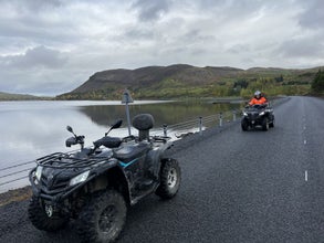 Travelers driving an ATV beside a lake in Southwest Iceland.