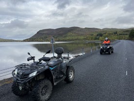 Reizigers rijden met een Quad langs een meer in Zuidwest-IJsland.