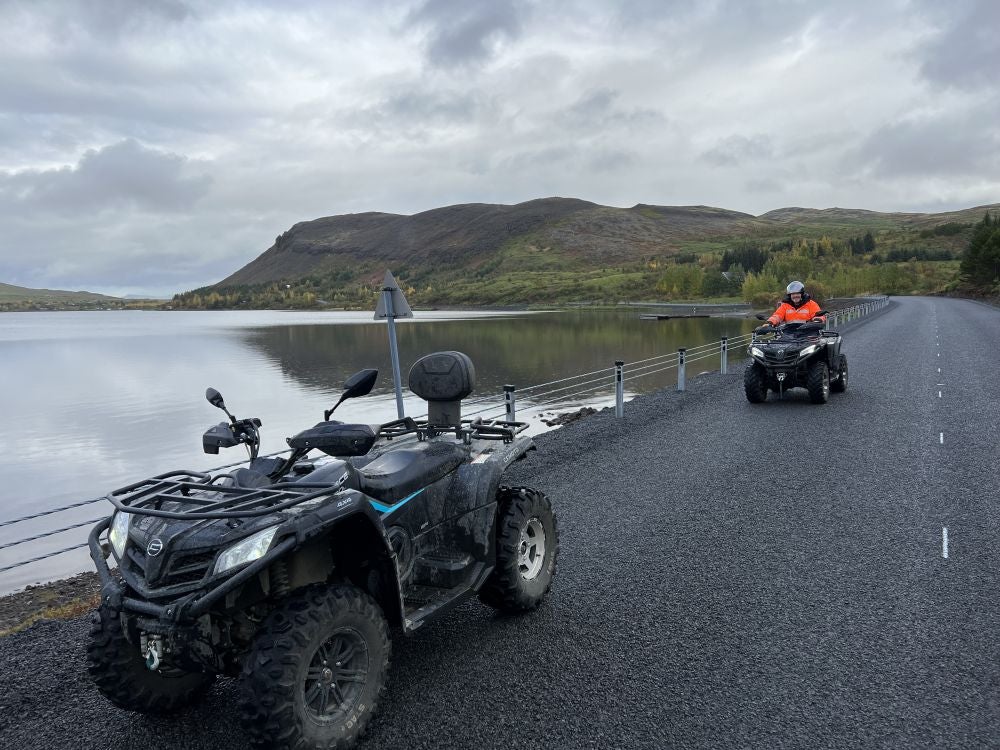 Viaggiatori alla guida di un veicolo ATV accanto a un lago nel sudovest dell'Islanda.