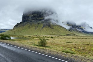 Misty air around the green and black landscape of a volcano on Iceland's South Coast.