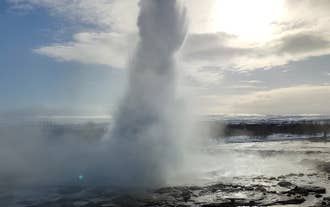 Gejseren Strokkur i det geotermiske område Geysir sender en imponerende vandsøjle højt op i luften.