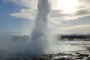 The Strokkur geyser at the Geysir geothermal area produces an impressive water display high into the air.