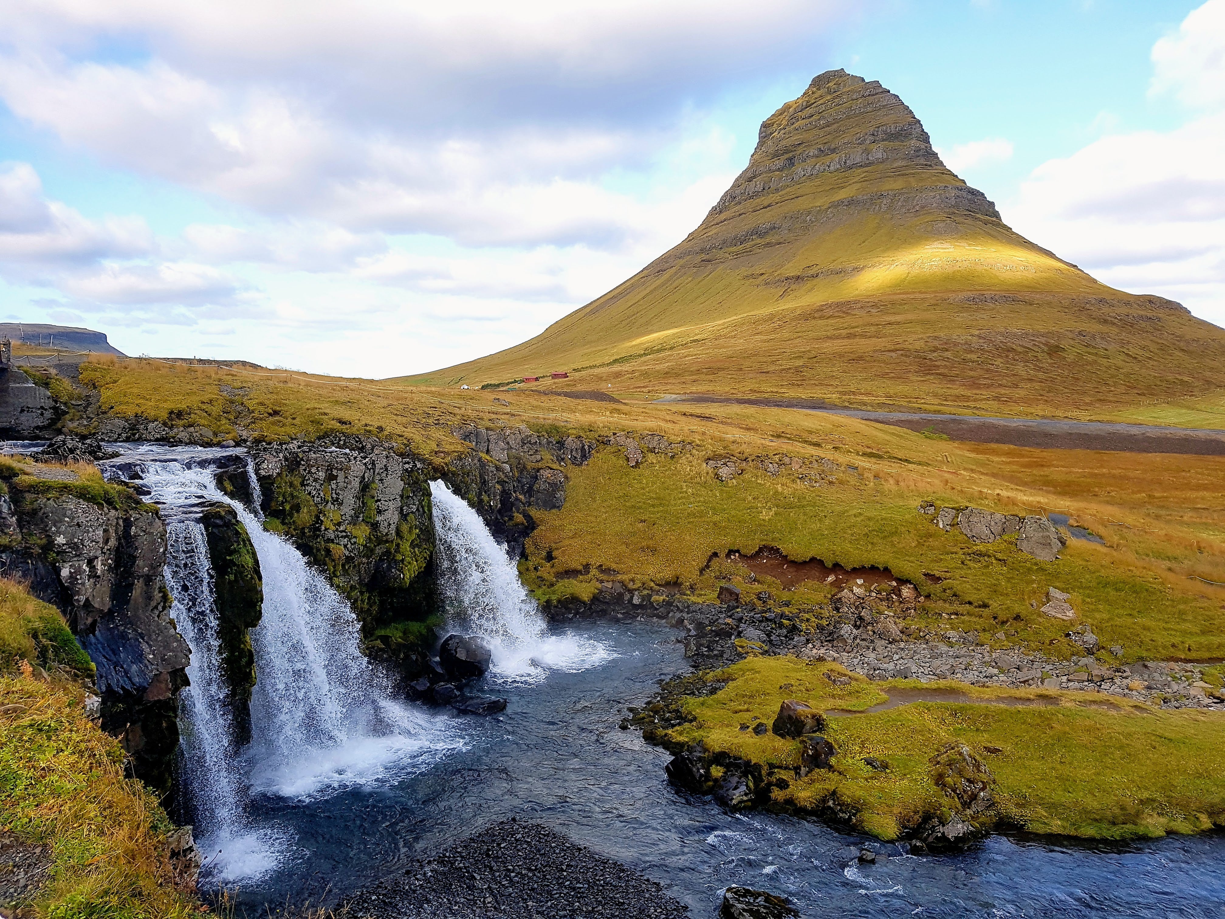 The cone-shaped Kirkjufell Mountain with the cascading Kirkjufellsfoss Waterfall in the foreground, Snæfellsnes Peninsula, Iceland.