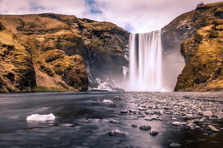The beautiful Skogafoss waterfall and its lush environment.