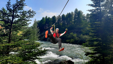 A man ziplines over a river on the Akureyri zipline tour.
