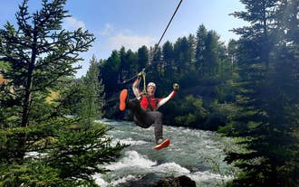 Een man ziplinet over een rivier tijdens de zipline tour door Akureyri.