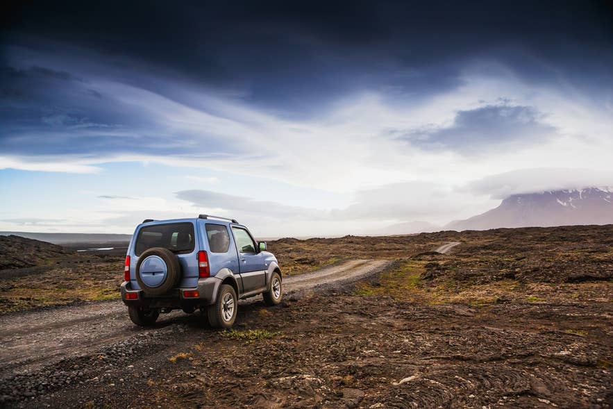 Small blue 4x4 on a rugged gravel road in Iceland's Highlands