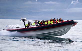 Un groupe de touristes profitant d'une excursion d'observation des baleines à bord d'un semi-rigide dans le nord de l'Islande.