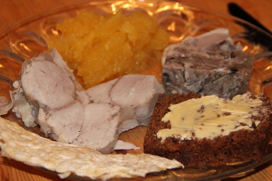 Hrutspunkar or pickled ram testicles on a plate with other traditional Icelandic foods