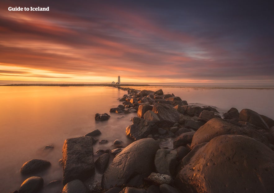 The Grotta Lighthouse near Reykjavik at sunset, surrounded by rocky shoreline and gentle ocean waves. The Grotta Lighthouse near Reykjavik at sunset, surrounded by rocky shoreline and gentle ocean waves.