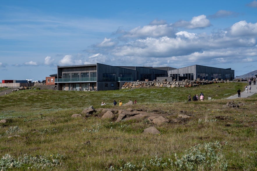 Gullfoss Visitor Center in Iceland’s Golden Circle, with modern wooden architecture, grassy surroundings, and tourists walking on a sunny day.