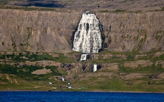 Dynjandi Waterfall cascading down steep cliffs in the Westfjords, viewed from across the bay.