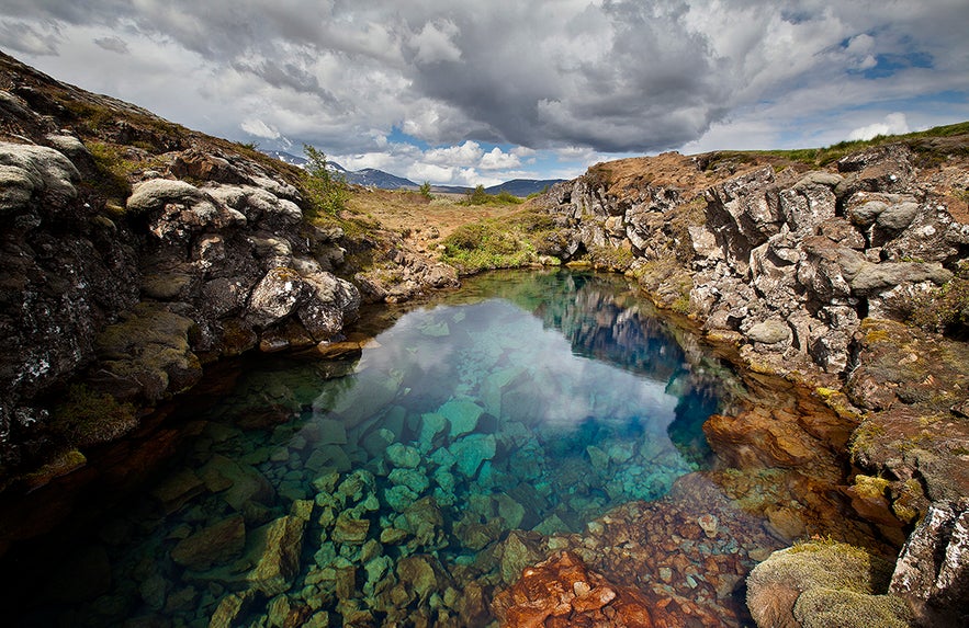 The Silfra Fissure in Thingvellir National Park has crystal-clear water surrounded by rocky formations. 